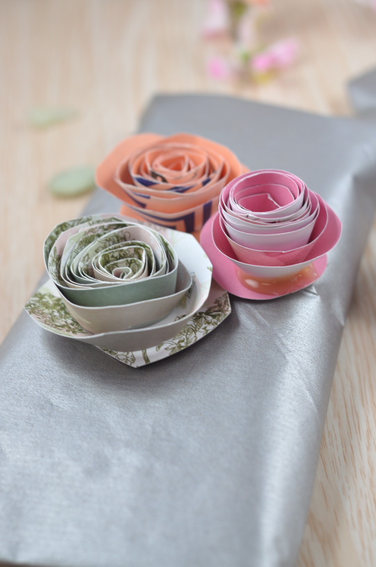 Aus buntem Papier kannst du ganz einfach wunderschöne Blumen basteln. Die DIY Idee ist einfach und zaubert ein wenig Frühling in dein Haus. Aber auch Geschenke kannst du mit den Papierblumen verzieren. 